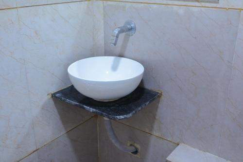a white sink on a wall in a bathroom at Hotel meet palace in Ambli Road