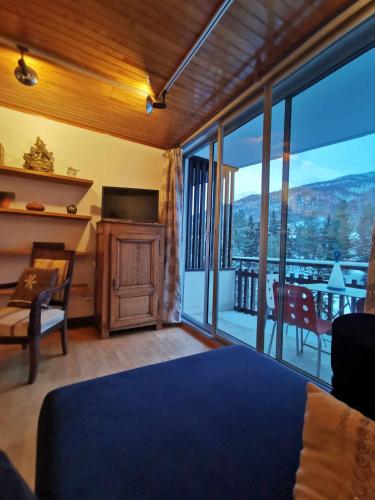 une chambre avec un lit et une grande fenêtre dans l'établissement Grand appartement 4 pers, face aux pistes, à La Salle Les Alpes