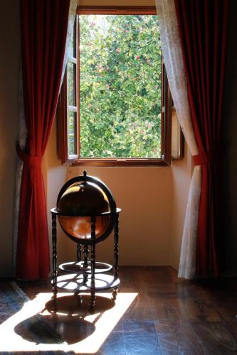 a chair in front of a window with red curtains at Pazo Torre Do Barrio in Loseiro