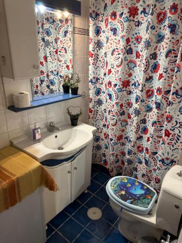 La salle de bains est pourvue d'un lavabo, de toilettes et d'un rideau de douche. dans l'établissement Mona Lisà, à Larissa