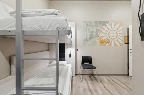 una habitación con una litera y una silla en Hotel Fyrtøjet, en Odense