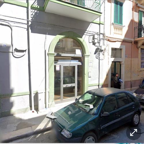 a green car parked in front of a building at rismondi 37 in Bari