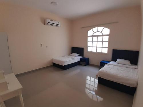 una habitación con dos camas y una ventana en EK Villa, en Ras al Khaimah