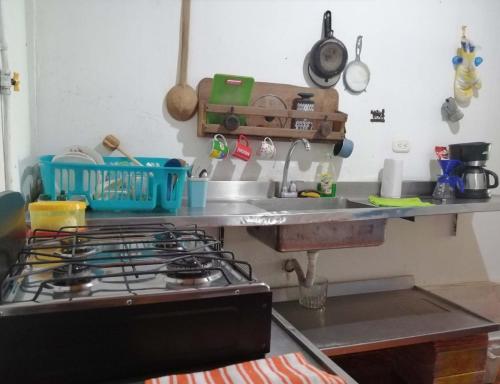 a kitchen counter with a stove and a sink at Casa Rio y Montaña in Honda
