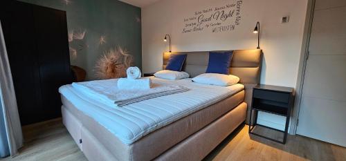 a bedroom with a large bed with blue sheets at Bosfluiter in Halle