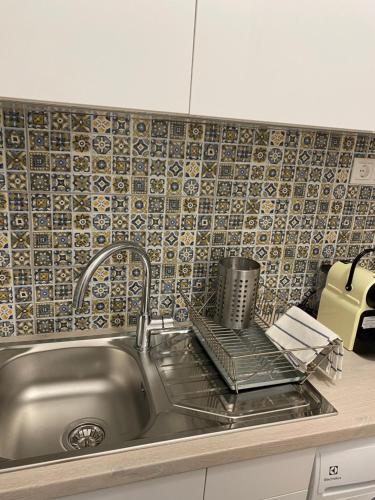 チョパクにあるVízipók apartmanの壁にタイルが貼られたキッチンのステンレス製シンク