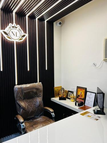 a leather chair sitting in a room with a table at Nirvana Lawn in Lucknow