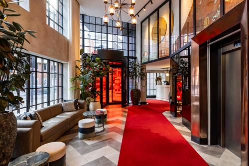 a lobby with a red carpet in a building at Virgin Hotels London - Shoreditch in London