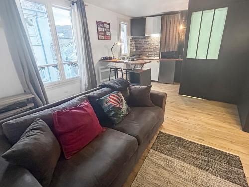 un salon avec un canapé et une cuisine dans l'établissement Studio Le Montebello - Vintage, WiFi et Netflix, à Fontainebleau