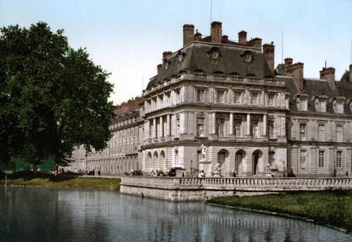 ein großes Gebäude neben einem Wasserkörper in der Unterkunft Studio Le Montebello - Vintage, WiFi et Netflix in Fontainebleau