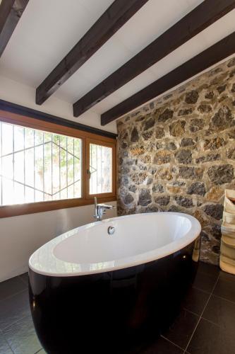 a large bath tub in a bathroom with a stone wall at MIMAR ALTEA VILLA l in Altea