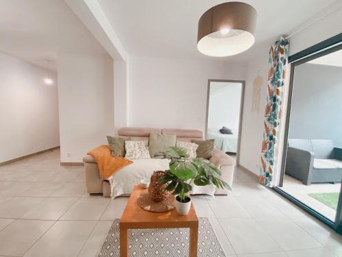 a living room with a couch and a table at 2 Chambres avec Balcon en Centre-Ville et Plage au Calme in Canet-en-Roussillon