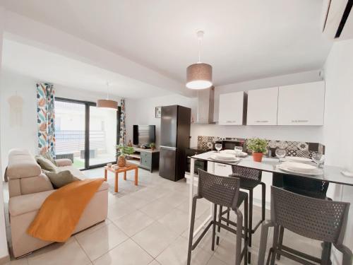 a kitchen and living room with a couch and a table at 2 Chambres avec Balcon en Centre-Ville et Plage au Calme in Canet-en-Roussillon