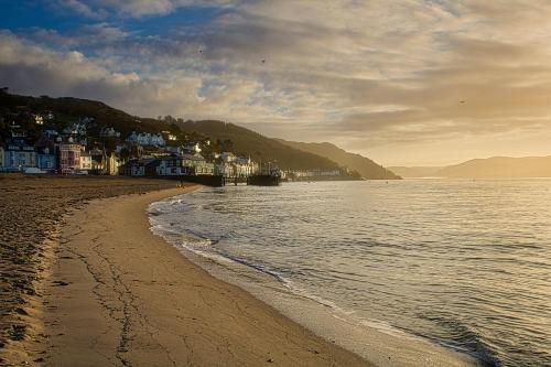 a view of a beach with houses and the water at Cosy 3 bedroom cottage by the sea in Aberdovey in Aberdyfi
