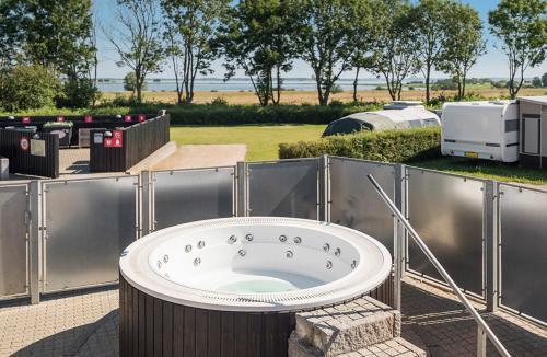 a bath tub on a patio with a trailer at First Camp Holbæk Fjord in Holbæk