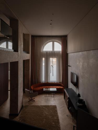 a living room with a couch and a window at Grand Hotel in Łódź