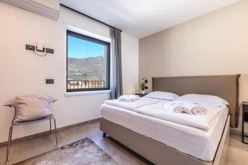 una camera da letto con un letto grande e una finestra di ELVY Garda Living Garden a Riva del Garda