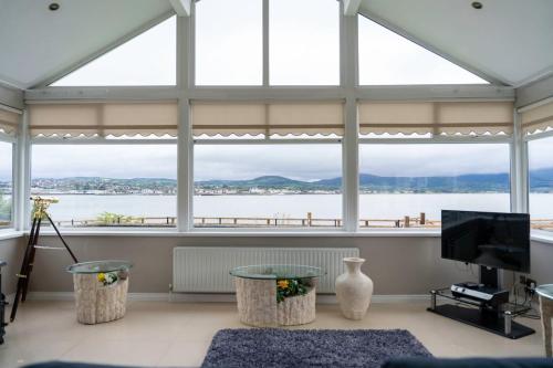 a living room with large windows and a view of the water at St Mary's Knocknagoran omeath in Ó Méith