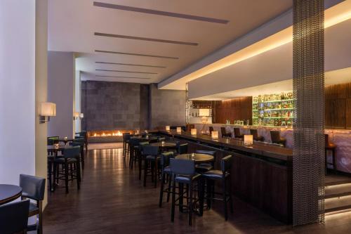 a restaurant with tables and chairs and a bar at Sofitel Cairo Downtown Nile in Cairo