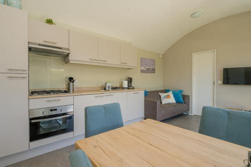 a kitchen and living room with a table and a couch at Buitenplaats Oudendijke in Ellemeet