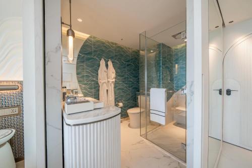 a bathroom with a shower and a sink and a toilet at Meliá Pattaya Hotel in Pattaya Central