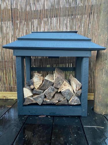 a pile of fire wood in a blue box at Cozy Cabin Retreat near Chepstow in Chepstow