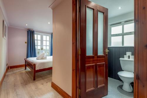 a bathroom with a toilet and a bed in a room at Poetry Peter's in Anstruther