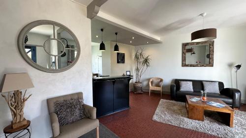 un salon avec un canapé et un miroir dans l'établissement Hotel Le Goeland, à Barbâtre