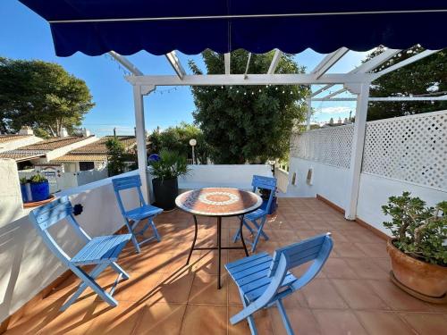 グラン・アラカントにあるCasa Azul de Agnesのテーブルと椅子と傘のあるパティオ