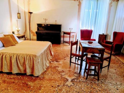 a bedroom with a bed and a table and chairs at Villa De Rubeis Florit in Tarcento
