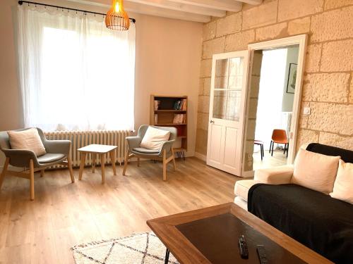 un salon avec un canapé, des chaises et une fenêtre dans l'établissement Ailanthus, à Saint-Aignan