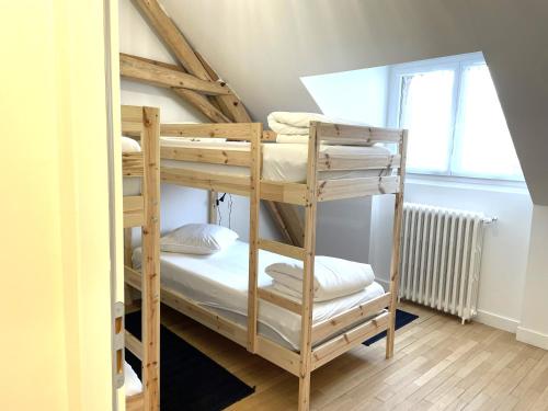 une chambre avec deux lits superposés et une fenêtre dans l'établissement Ailanthus, à Saint-Aignan
