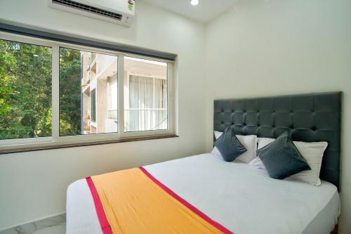 a bedroom with a large bed with a large window at Baga Creek Side Nest in Baga