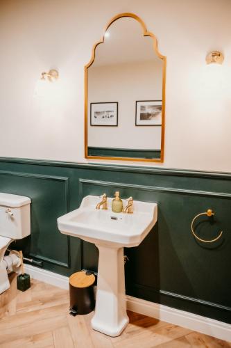 a bathroom with a sink and a mirror at Morlun, Trearddur Bay, Isle of Anglesey in Trearddur