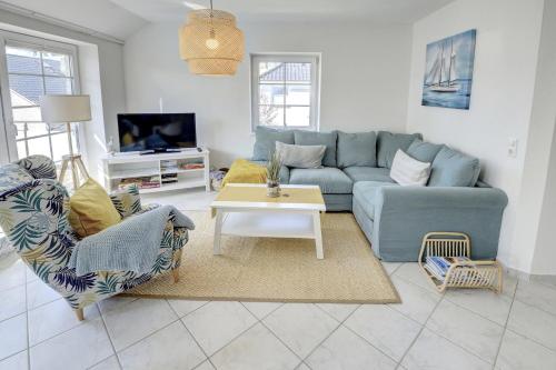a living room with a blue couch and a table at Dünengras in Schausende