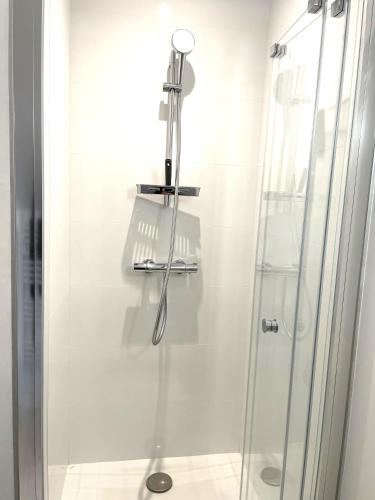 une douche dans une salle de bain avec une porte vitrée dans l'établissement Ailanthus, à Saint-Aignan