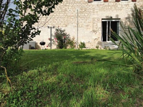 a grassy yard with a building in the background at Le puech des Amandiers in Villeneuve-sur-Vère