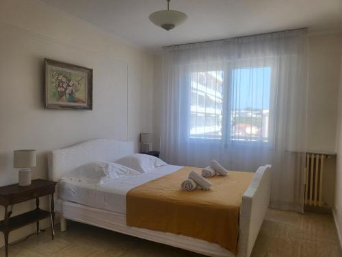 ein Schlafzimmer mit einem Bett, auf dem zwei Handtücher liegen in der Unterkunft Le Cambridge Juan in Antibes