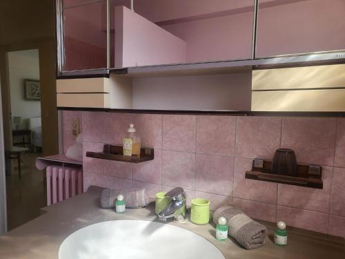 ein Badezimmer mit einem Waschbecken und einer rosa Wand in der Unterkunft Le Cambridge Juan in Antibes