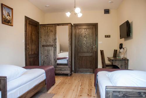 a bedroom with two beds and a television in it at Hotel Pod Kogutkiem in Krzywaczka