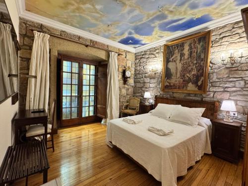 a bedroom with a bed and a stone wall at Palacio Pampinot in Hondarribia