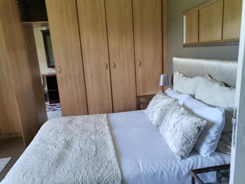 a bedroom with a bed with white sheets and pillows at Green Hills Farm House in Drummond