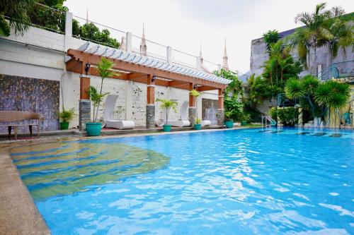 a large pool with blue water in a building at Punta Verde Resort & Convention Center in Pansol