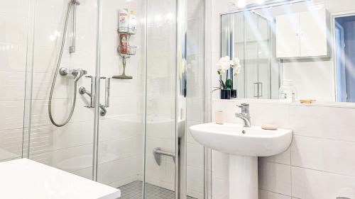 une salle de bain blanche avec une douche et un lavabo dans l'établissement Sea & City View, à Nice