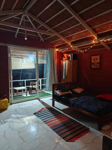a bedroom with a bed and a window with a table at Lalitha Farm Stay in Tumkūr