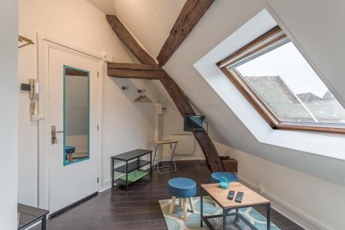 Cette chambre mansardée dispose d'une fenêtre et d'une table. dans l'établissement Le Petit Bouchon - Studio - Hypercentre, à Troyes