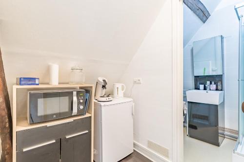 une petite cuisine avec un micro-ondes et un réfrigérateur dans l'établissement Le Petit Bouchon - Studio - Hypercentre, à Troyes