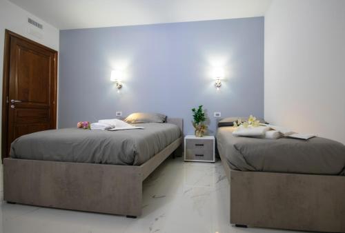 two beds sitting in a room withermottermottermott at Morcone B&B Affittacamere in Morcone