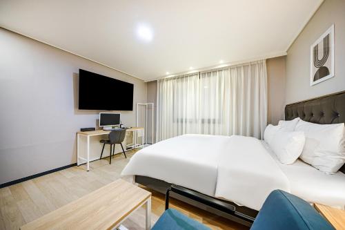 a hotel room with a bed and a tv at Brown Dot Hotel Angang in Gyeongju