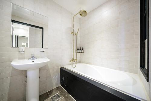 慶州市にあるBrown Dot Hotel Angangの白いバスルーム(シンク、バスタブ付)